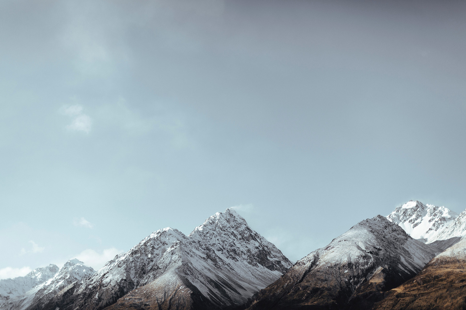 Magnifiques montagnes enneigées sous un ciel clair, symbolisant la fraîcheur et la sérénité des parfums My Aura inspirés de la saison hivernale.