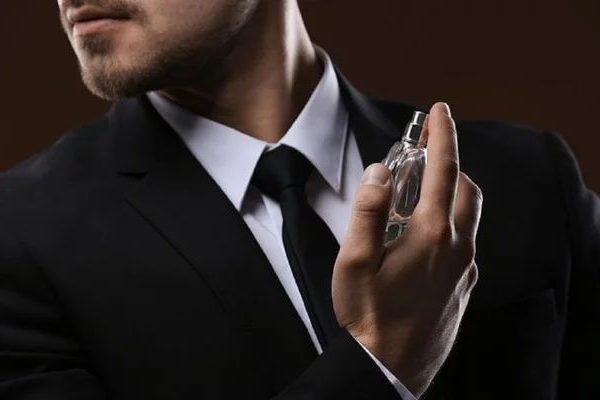 Jeune homme élégant s'aspergeant d'un parfum My Aura, une fragrance de luxe issue d'une fabrication minutieuse, inspirée des quatre saisons.